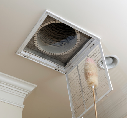 Senior man cleaning air conditioning filter in ceiling